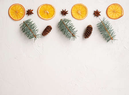Pattern on light background, celebration frame. New Year card with Christmas tree and dry oranges, cones and anise, holiday template with fir and decorations. Mock up with place for text, copy space.の写真素材