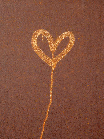 Symbol of love, romantic concept. Heart painted on rusty surface. Corrosion of metal texture closeup. Heavily corroded metal sheet. Abstract art.の写真素材