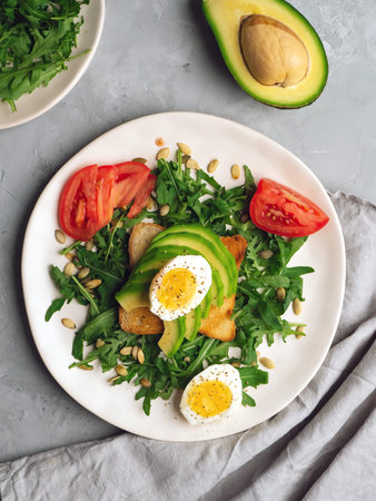 Clean eating. Healthy avocado toasts for breakfast or lunch with bread, arugula, sliced avocado,...