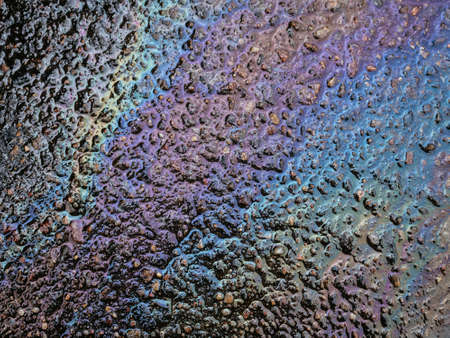 Abstract background with oil stain of oil products. Multicolored grunge texture. Gasoline fuel spots on wet asphalt road. Ecology and environmental pollution concept.の写真素材