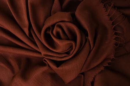 Deep, rich, brown colored cashmere scarf. Folded and flowing background. Decoration design. Soft focus. Luxury fashion concept. Dark chocloate backdrop with curves. Smooth elegant wrinkled fabric.の写真素材