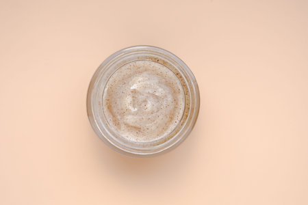 Facial scrub mask in jar on pastel background. Cosmetic product. Care for face. Morning or evening...