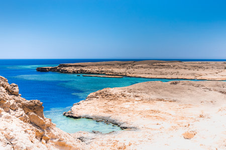 Sandy and rocky coast with blue color of water. Desolate beach on the coast shore of Red Sea. Ras Muhammad in Egypt at the southern extreme of the Sinai Peninsula. Travel conceptの写真素材