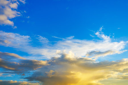 Majestic dusk. Beautiful bright blue sky with vivid golden clouds. Soft cloud in twilight. Calm cloudy sky on evening time. Abstract nature background. Fresh air, weather and freedom conceptの写真素材