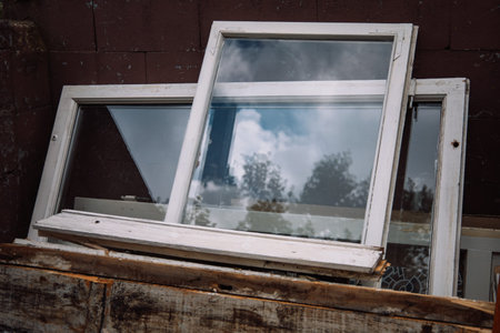 Construction waste for disposal. Heap of old wooden window frames with glass outdoors. Renovation...