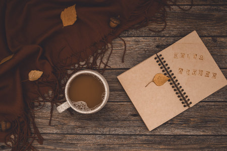 Atmospheric autumn composition. Fall background with mug of coffee, deep brown cashmere scarf and...
