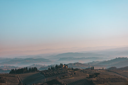 Early smoggy morning in San Gimignano, Italy. Beautiful vineyards countryside landscape on sunrise. Amazing Tuscany, Europe. Travel concept.の写真素材