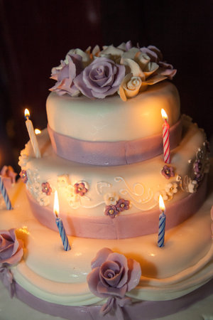 a beautiful wedding cake with burning candles
