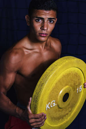 athlete lifts a weight of cast iron on the chestの写真素材