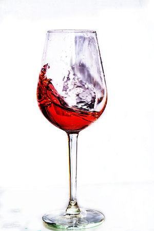 Colored drink in a crystal glass on a white background