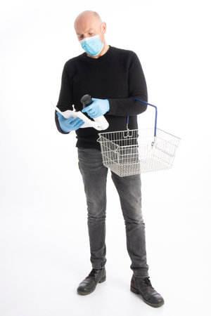 Man with mouth protection and hand gloves starting to clean a shopping cart, isolated on white backgroundの写真素材
