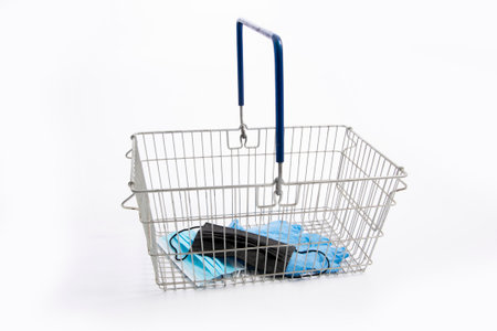 Shopping basket with mouth protection and hand gloves, isolated on white backgroundの写真素材
