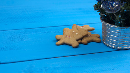 Gingerbread and Christmas tree on blue table