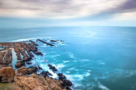 View of a beautiful misty sea from a view point on a beach in Mossel Bay, Mossel Bay, South Africaの写真素材