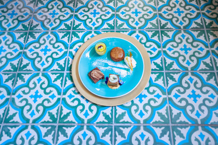 Chocolate brownie, malva pudding, pumpkin spice cake with glazed frosting and lemon curd in a small glass on a colorful plate with icing sugar decorationsの写真素材