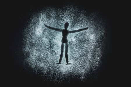 Wooden Human Manikin lying in white snow powder making snow angels with a black background
