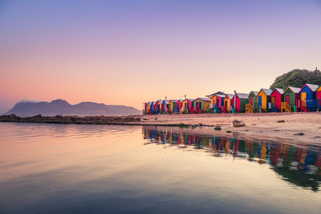 View of the beautiful sunset over False Bay from Kalkbay with little coloured houses on the beach,...