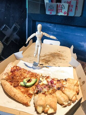 Wooden Human Manikin eating a delicious Pizza, in a restaurantの写真素材