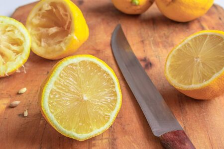 Yellow lemons (Citrus limon) cut up and ready to used on a wooden chopping board, Cape Town, South Africaの写真素材