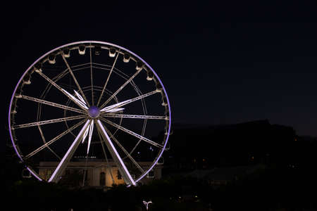 View of Table Mountain and a big white Ferris wheel located at the waterfront at sunset on a beautiful calm evening, Cape Town, South Africaの写真素材