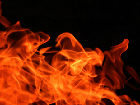 Texture of bright fire flames on a black backgroundの写真素材
