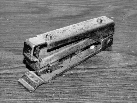 Old rusty stapler on a black and white background close-upの写真素材