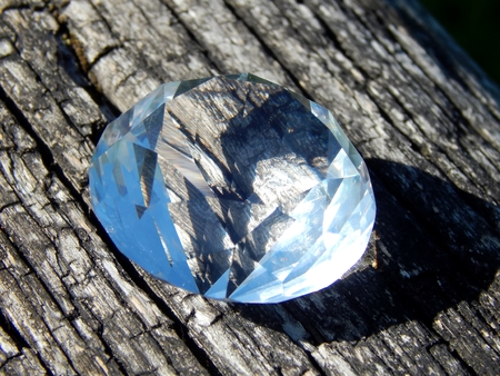 Transparent diamond on a wooden background close-upの写真素材