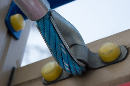 A detailed closeup macro of a rope mooring line fastened to a cleat.