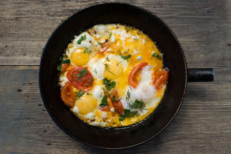 Fried eggs in a pan with vegetables.の写真素材
