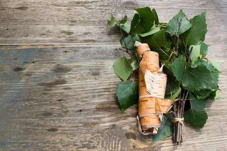 green leaves and birch bark on a wooden background, space for textの写真素材