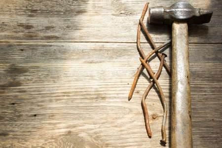 old rusty nails and hammer on wooden background, space for textの写真素材