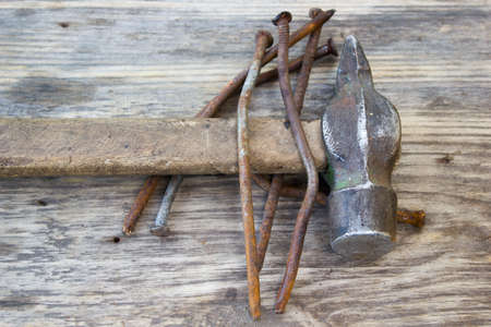 old rusty nails and hammer on wooden backgroundの写真素材