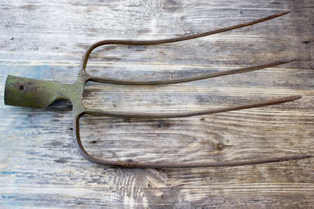 pitchfork on a wooden background. Old garden tools.の写真素材