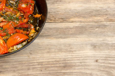 frying pan with scrambled eggs and tomatoes on wooden rustic table. Copy space to right.の写真素材