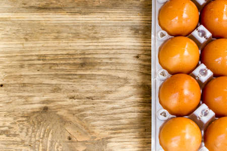 Eggs in box on a wooden table. Copy space to right.の写真素材