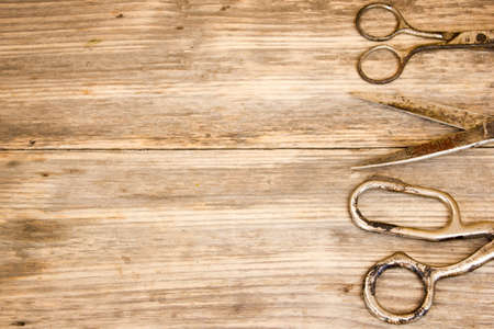 Old scissors on wooden background. Copy space to right.の写真素材