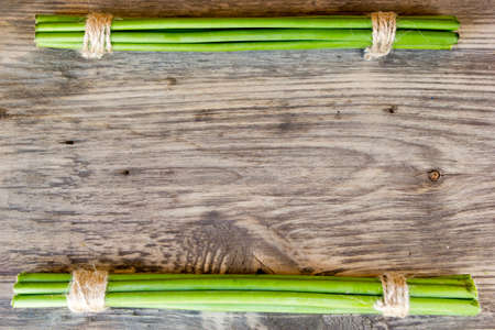 Green garlic sticks on rustic wooden table  with copy spaceの写真素材