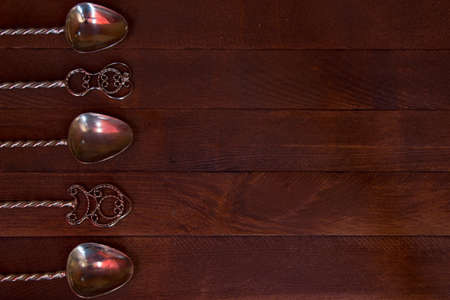 silver teaspoon arranged over dark wooden table, top viewの写真素材