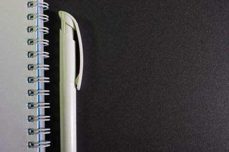 blank white notebook, pen on the desk