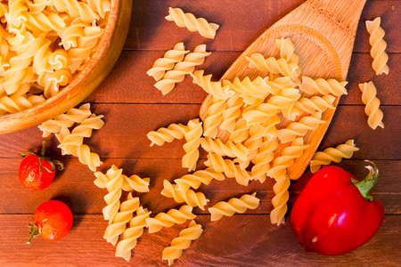 Italian farfalle pasta on wooden spoon on wooden tableの写真素材