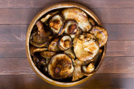mushrooms in plate on wooden backgroundの写真素材