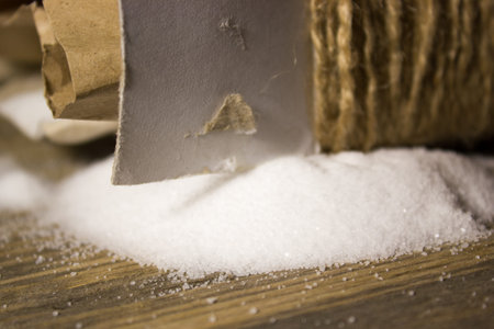 Small table Salt in Kraft box spilled on the wooden backgroundの写真素材