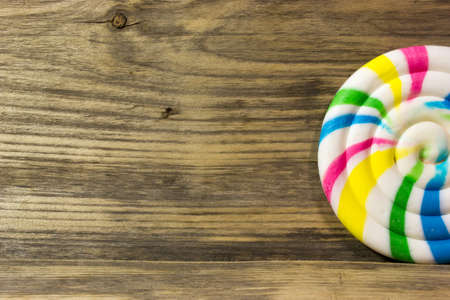 Round spiral color candy on wooden background.の写真素材