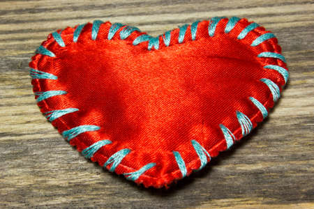Red heart fabric on wooden backgroundの写真素材
