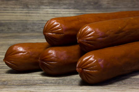 Smoked beer sausages on wooden background.の写真素材