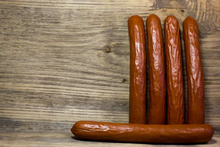 Smoked beer sausages on wooden background.の写真素材