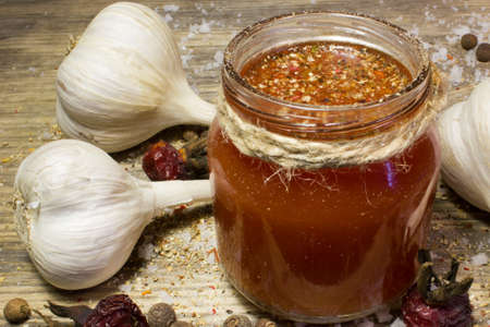 A glass of tomato juice with garlic and spices on wooden background.の写真素材