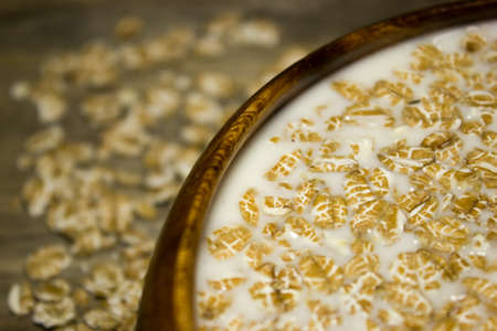 Wheat flakes and milk in a wooden plateの写真素材