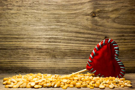 Crushed dried peas and a red love heart on wooden backgroundの写真素材