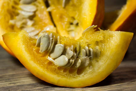 Cut slices of pumpkin seeds on wooden backgroundの写真素材